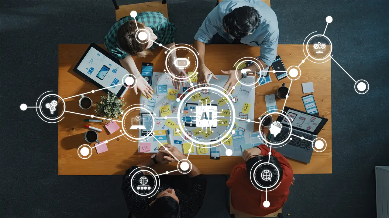 Eine Gruppe arbeitet an einem Tisch an einem Projekt mit Technologie- und AI-Themen. Digitale Symbole verbinden Konzepte wie Netzwerk, Roboter und Cloud. Tablets und Laptops sind Teil der Szene.
